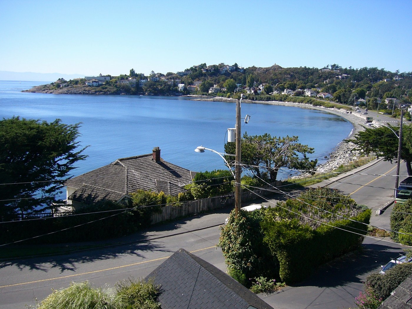 Beach Drive curving along McNeill Bay in Oak Bay, seen from above the road.