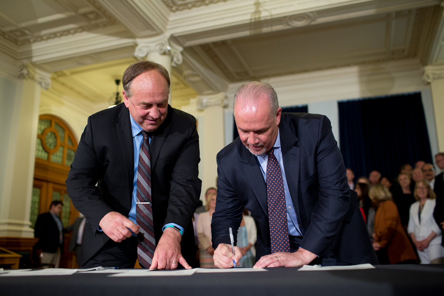Andrew Weaver, left, and John Horgan signing their 2017 agreement at the B.C. legislature